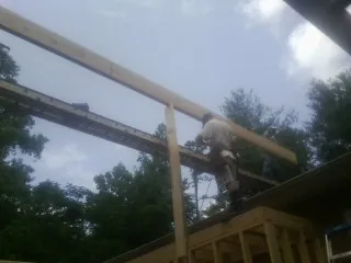 Carpenter setting a ridge beam over a new addition frame — Ice Dam Removal by Roofing Brothers in Chaptico