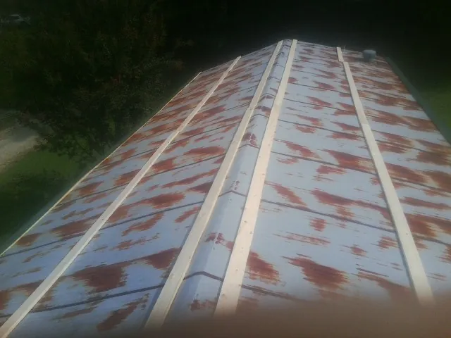 Rusted metal roof panels with new wood purlins before replacement — Storm Damage Roof Repair in Chaptico by Roofing Brothers