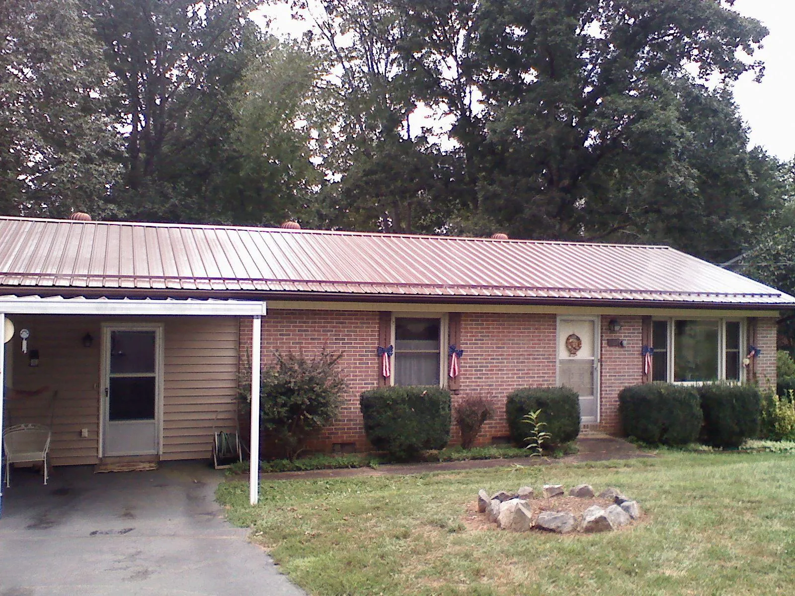 Bronze metal roof and carport on a brick ranch home — Roof Repair work by our crew in Chaptico